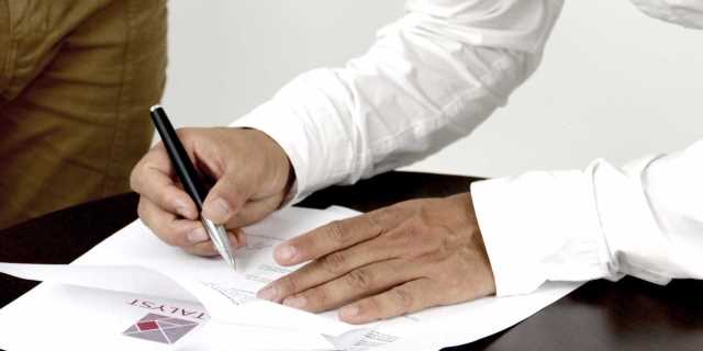 Una persona firma un documento