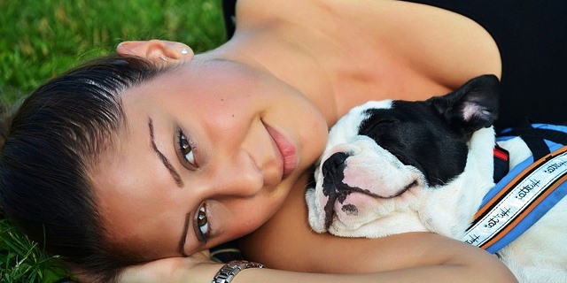 fotos de una mujer sonriendo tumbada con un perrito