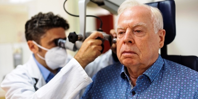 Un doctor examina los oídos de su paciente