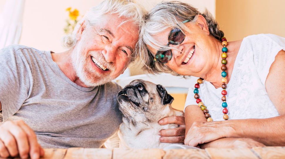Pareja de personas mayores acompañada de un perro pequeño