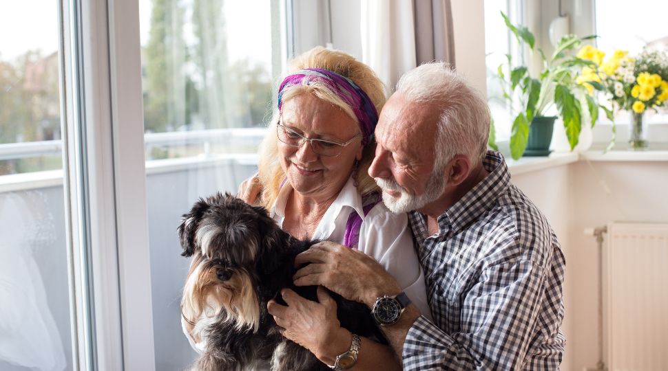 Pareja de personas mayores acompañada de un perro pequeño